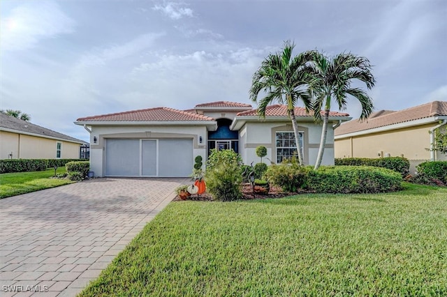 mediterranean / spanish house featuring a front lawn and a garage