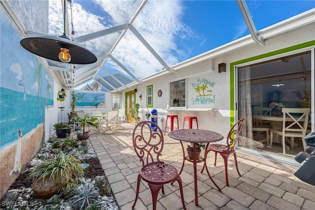 view of patio featuring glass enclosure