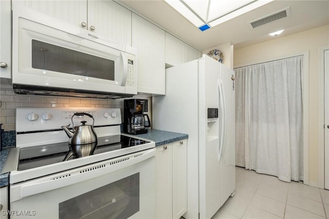 kitchen featuring light tile patterned floors, decorative backsplash, white cabinetry, and white appliances