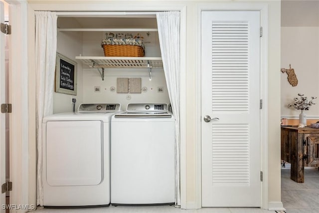 laundry room featuring washer and dryer and light tile patterned floors