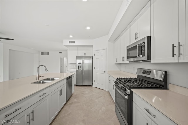 kitchen featuring white cabinets, appliances with stainless steel finishes, ceiling fan, and sink