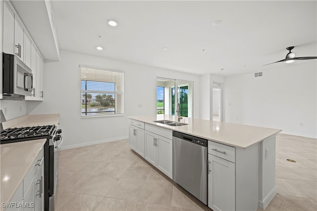 kitchen featuring a center island with sink, sink, ceiling fan, white cabinetry, and stainless steel appliances