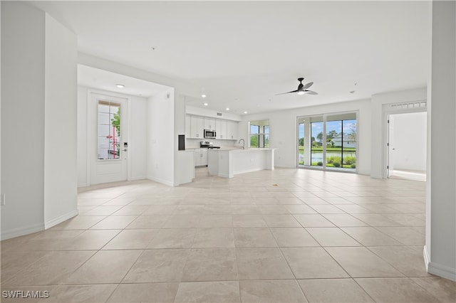 unfurnished living room featuring light tile patterned floors and ceiling fan