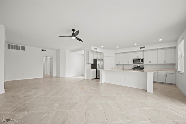 kitchen featuring a kitchen island with sink, white cabinets, sink, ceiling fan, and appliances with stainless steel finishes