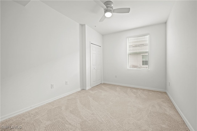 carpeted empty room featuring ceiling fan