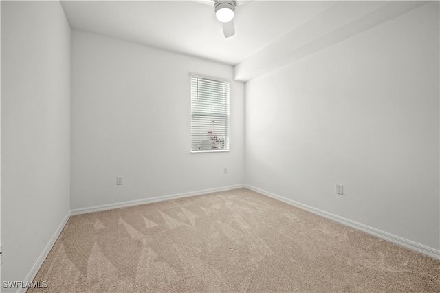 spare room with ceiling fan and light carpet