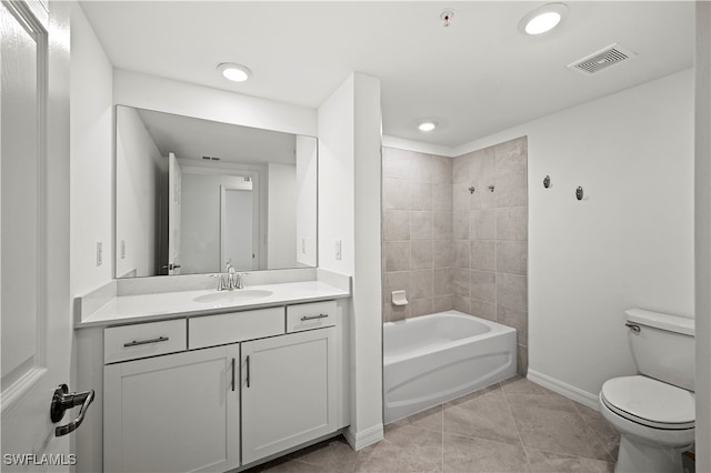 full bathroom featuring tile patterned floors, vanity, tiled shower / bath combo, and toilet