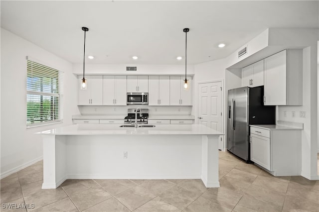 kitchen with sink, white cabinetry, stainless steel appliances, and an island with sink