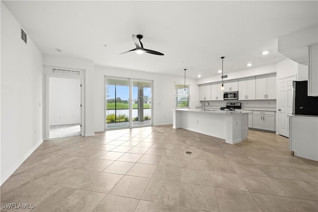 kitchen featuring white cabinetry, ceiling fan, hanging light fixtures, stainless steel appliances, and a kitchen island with sink