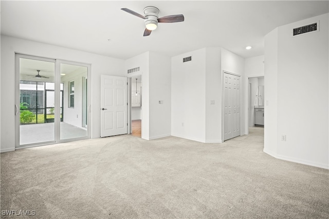 unfurnished bedroom featuring ceiling fan, light carpet, access to outside, and a closet