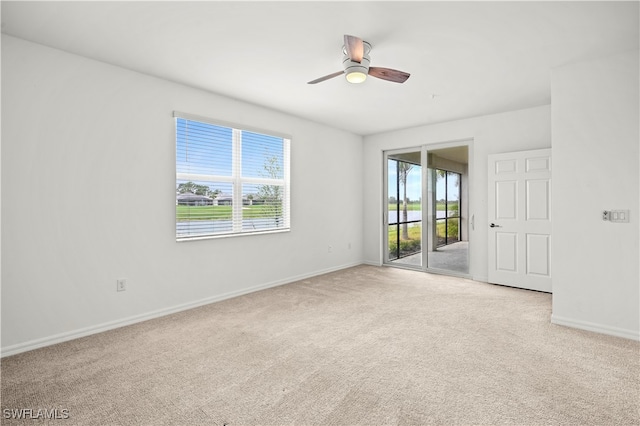 spare room featuring light carpet and ceiling fan