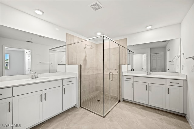 bathroom featuring tile patterned flooring, vanity, and a shower with shower door