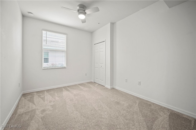 carpeted spare room featuring ceiling fan