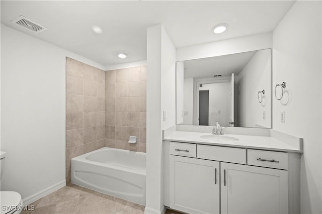 full bathroom with tile patterned floors, vanity, tiled shower / bath combo, and toilet