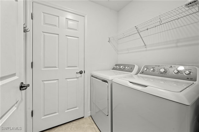 washroom featuring light tile patterned flooring and washing machine and dryer