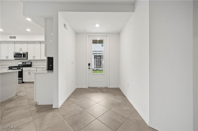 kitchen featuring white cabinetry, light tile patterned flooring, and appliances with stainless steel finishes