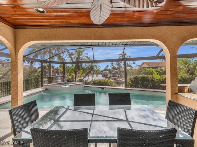 view of pool with a lanai and an in ground hot tub