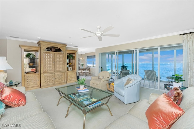 living room featuring ceiling fan, crown molding, a water view, and a healthy amount of sunlight