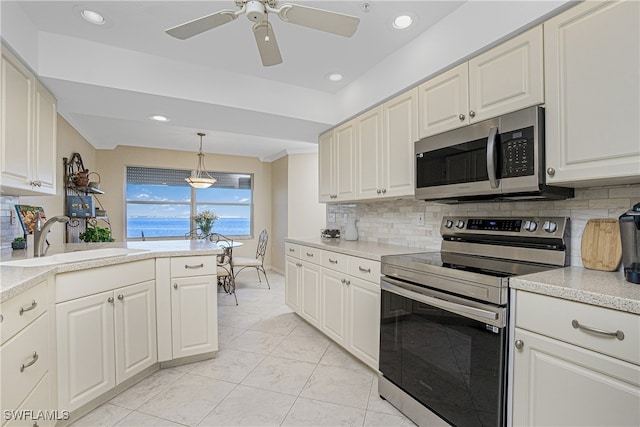 kitchen with ceiling fan, sink, stainless steel appliances, tasteful backsplash, and pendant lighting