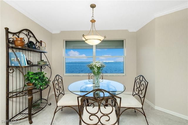 dining area with light tile patterned floors, a water view, and crown molding