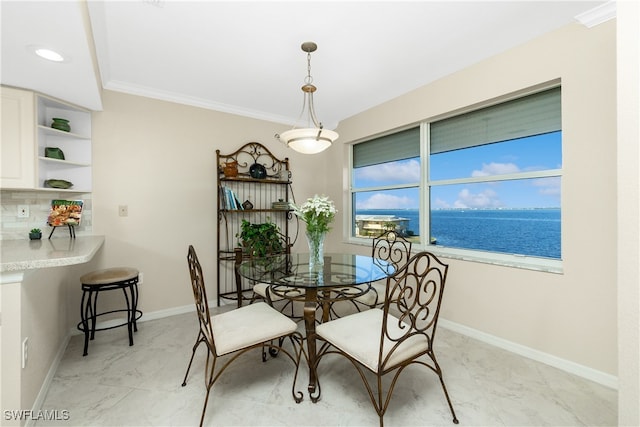 dining room featuring a water view and ornamental molding