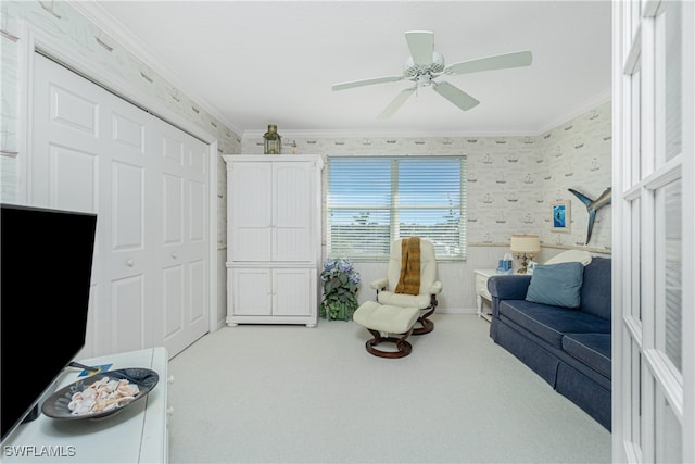 living area featuring crown molding, ceiling fan, and light colored carpet