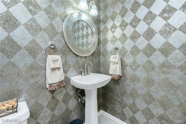 bathroom with toilet and tile walls