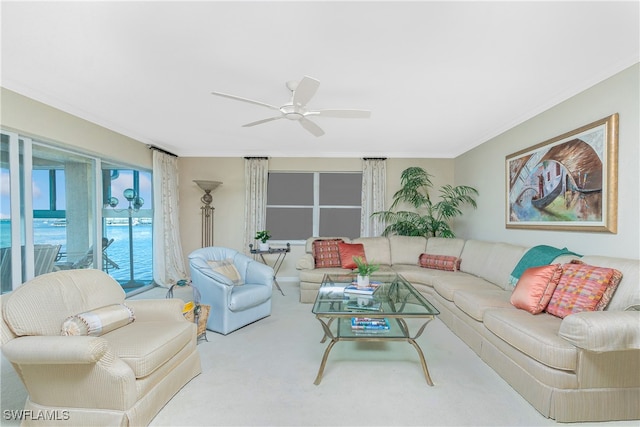 carpeted living room with ceiling fan and ornamental molding