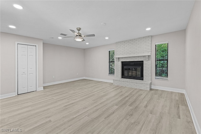 unfurnished living room featuring ceiling fan, light hardwood / wood-style floors, and a fireplace