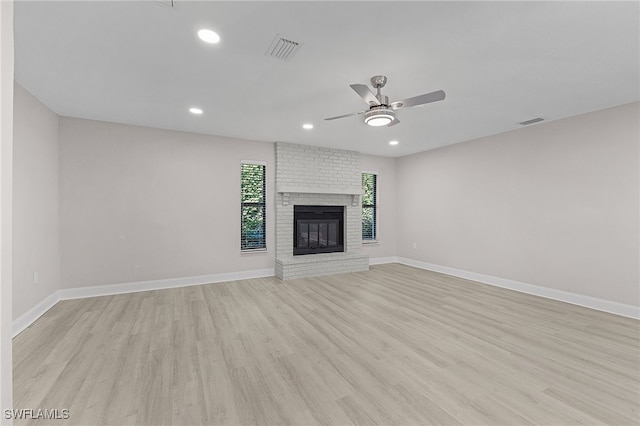 unfurnished living room featuring ceiling fan, a fireplace, and light hardwood / wood-style floors