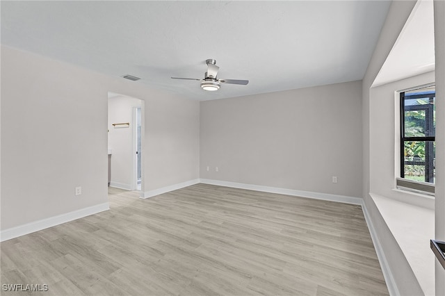 empty room with ceiling fan and light hardwood / wood-style flooring