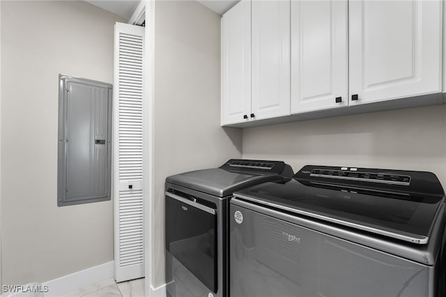 laundry room with electric panel, separate washer and dryer, and cabinets