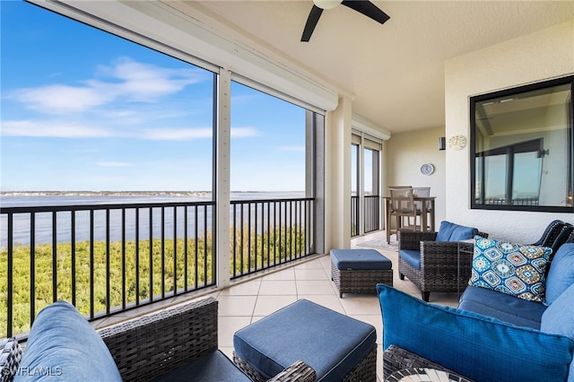 sunroom / solarium with ceiling fan and a water view