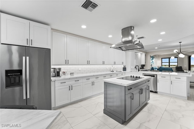 kitchen featuring white cabinets, ornamental molding, appliances with stainless steel finishes, island range hood, and kitchen peninsula