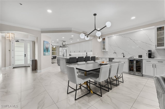 dining space with wine cooler and crown molding