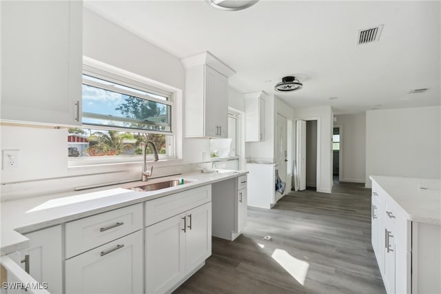 kitchen with white cabinetry, sink, a center island, and dark hardwood / wood-style floors