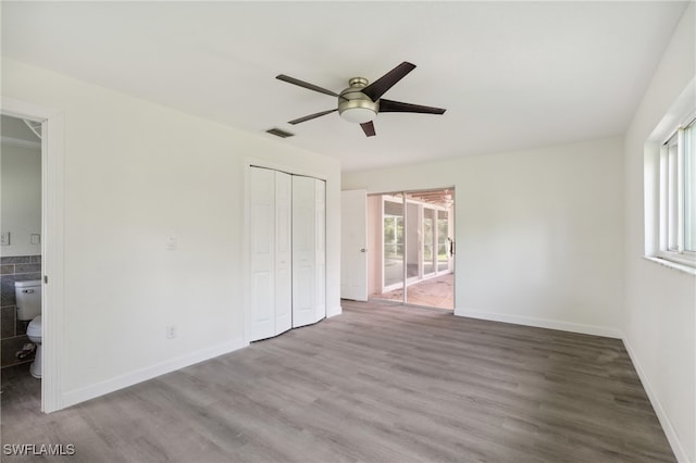 unfurnished bedroom featuring connected bathroom, ceiling fan, a closet, and wood-type flooring