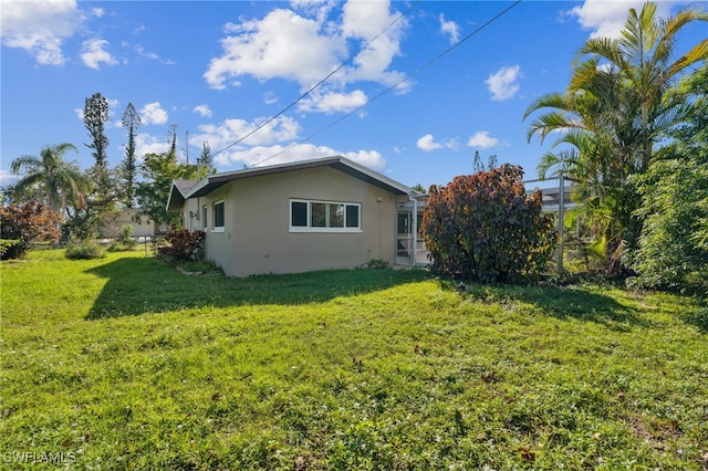 view of side of home featuring a lawn