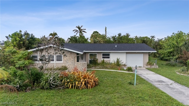 ranch-style home featuring a garage and a front lawn