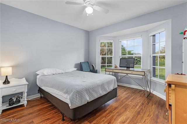 bedroom with dark hardwood / wood-style flooring and ceiling fan