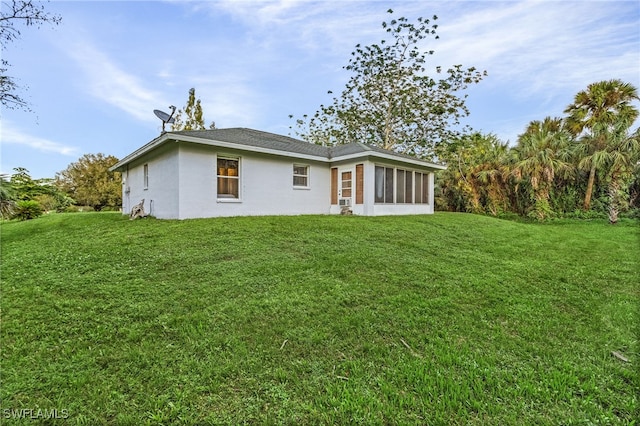 back of property featuring a yard and a sunroom