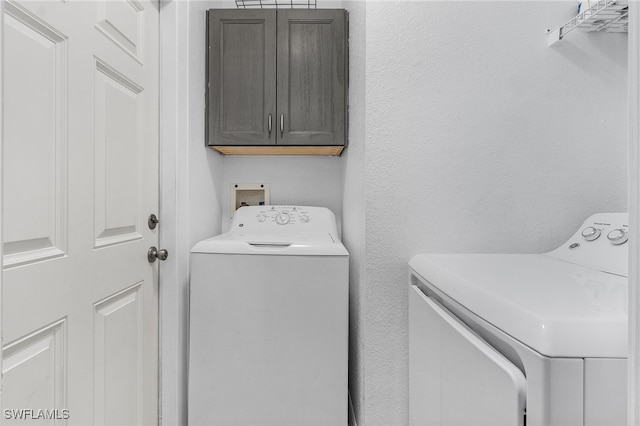 laundry room featuring cabinets and washing machine and clothes dryer