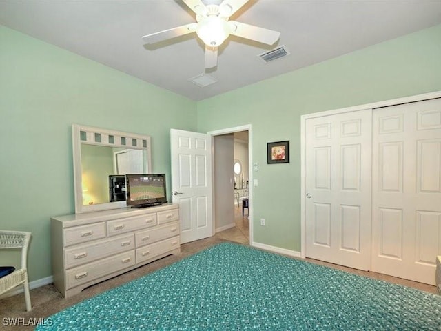 carpeted bedroom featuring ceiling fan and a closet