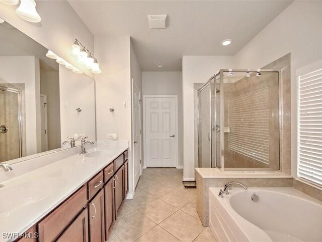 bathroom with tile patterned flooring, vanity, and independent shower and bath