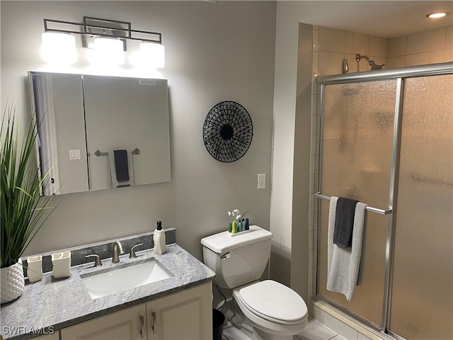 bathroom featuring toilet, vanity, and walk in shower