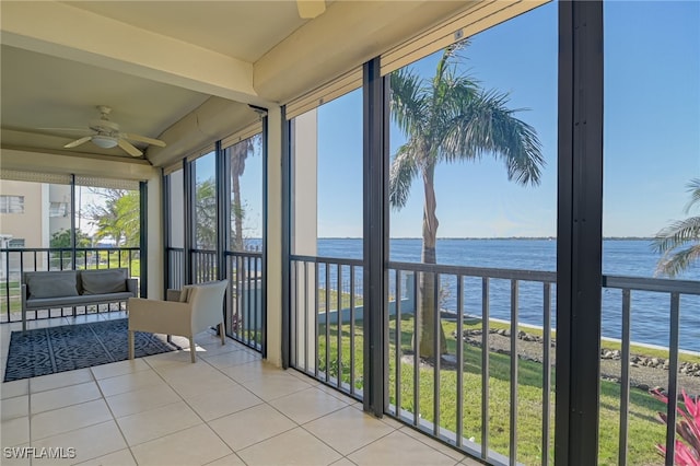 unfurnished sunroom with ceiling fan and a water view