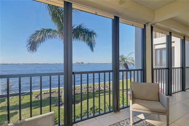 sunroom featuring a water view