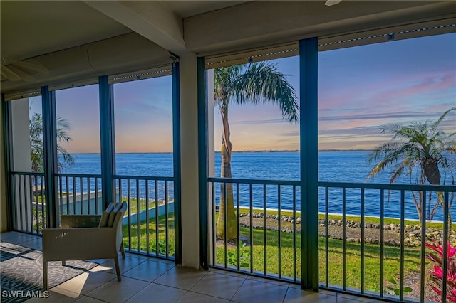 sunroom / solarium featuring a water view