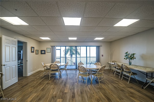 dining space featuring a paneled ceiling and dark wood-type flooring