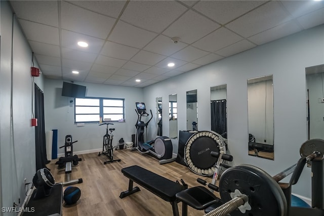 gym with wood-type flooring and a paneled ceiling